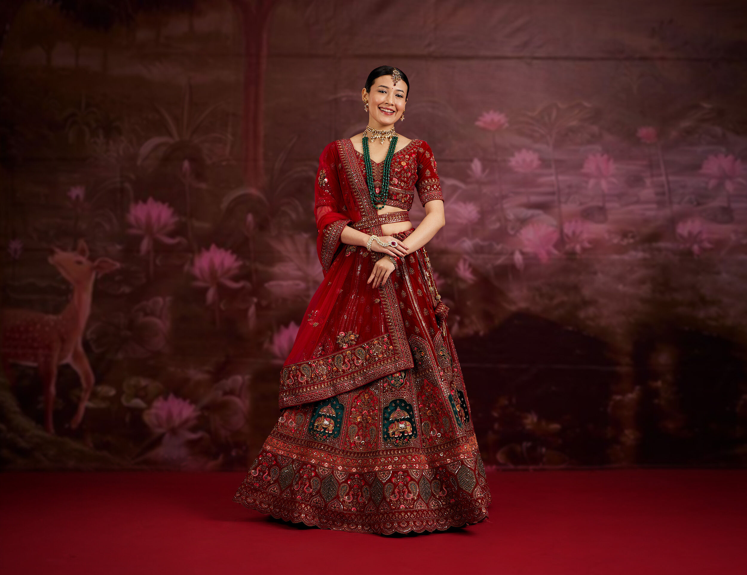 Woman flaunting a luxurious designer red lehenga, ideal for winter wedding fashion.